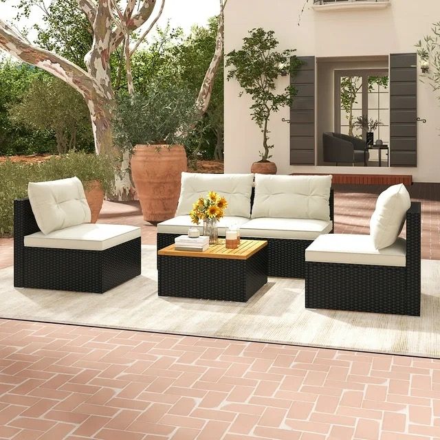 an outdoor living room with furniture and potted plants