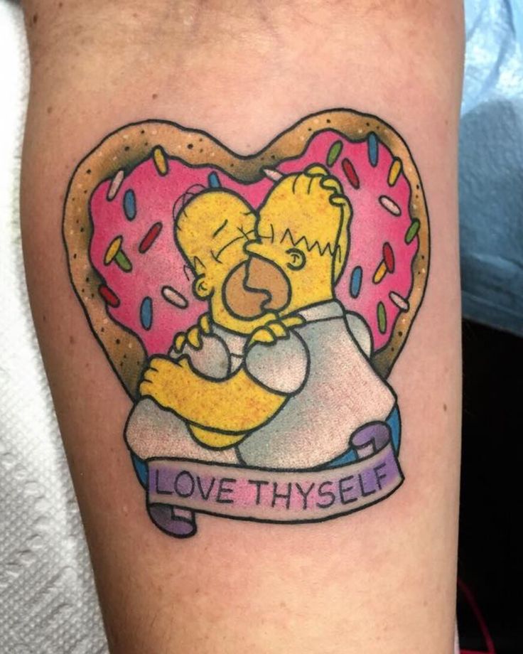 a tattoo on the arm of a person with a donut and heart shaped doughnut