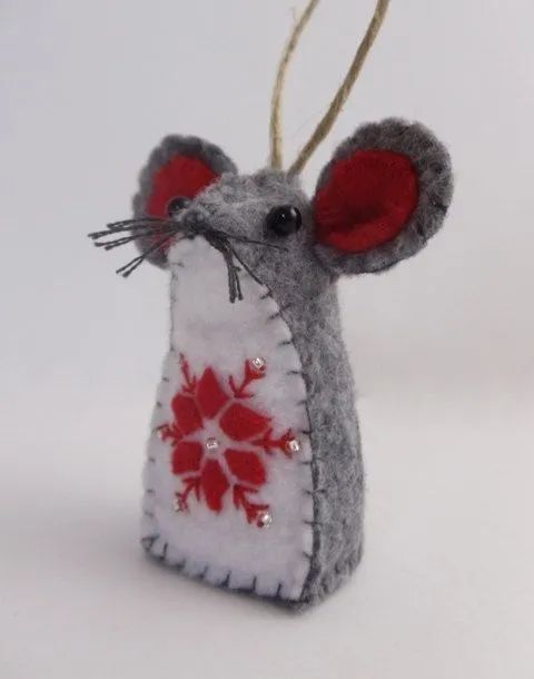 a gray and red mouse ornament hanging from a string on a white background