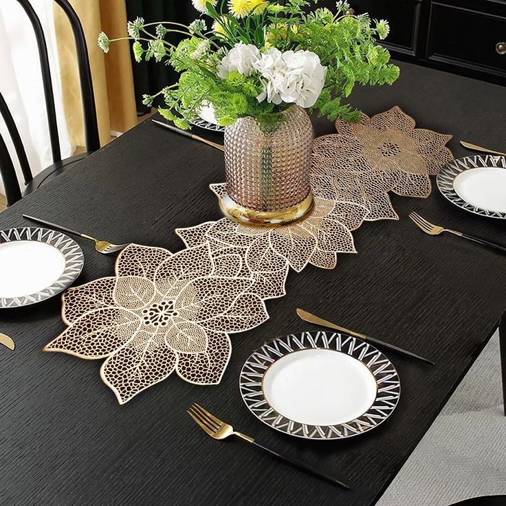 a black table topped with plates and flowers