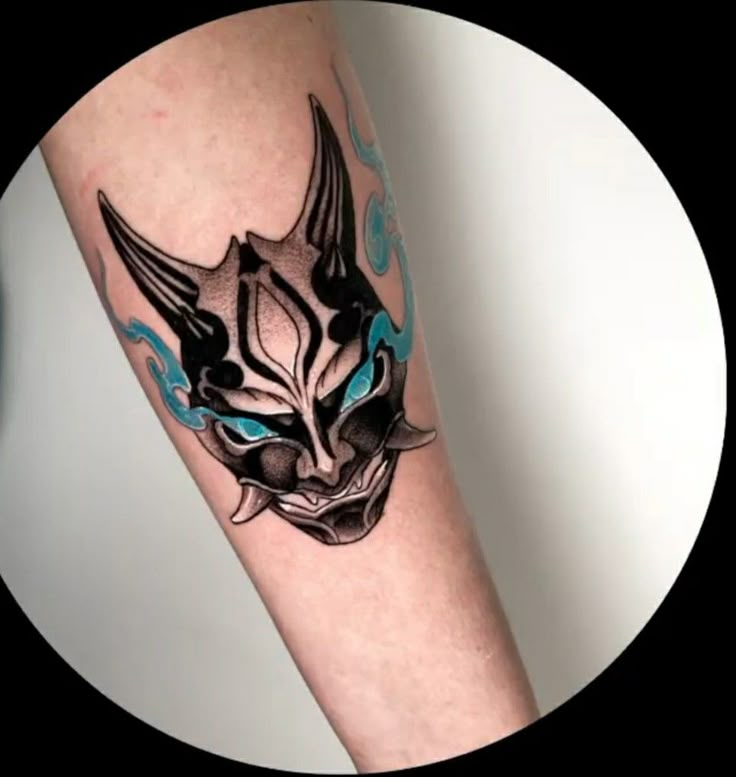 a black and blue cat tattoo on the right arm with an evil look to it's face