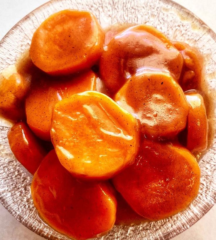 a glass bowl filled with sliced oranges on top of a table