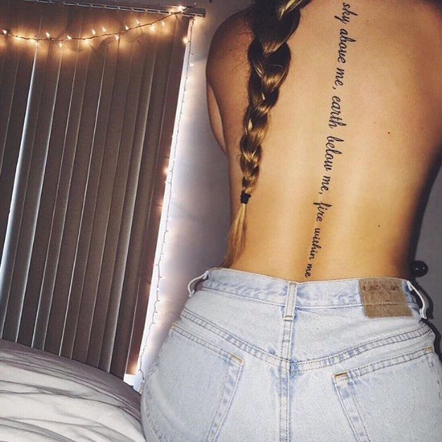 the back of a woman's body with tattoos on her upper and lower back