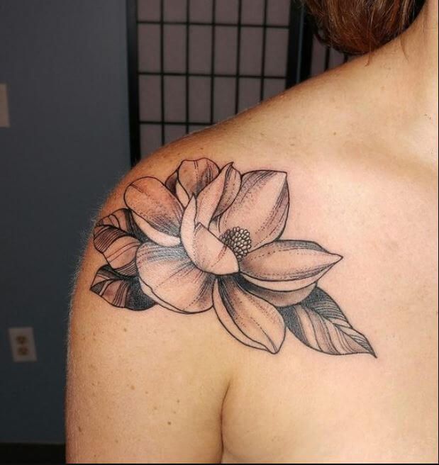 a woman's shoulder with a flower tattoo on the left side of her chest