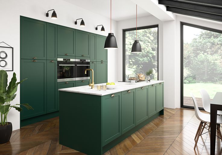 a kitchen with green cabinets and white counter tops