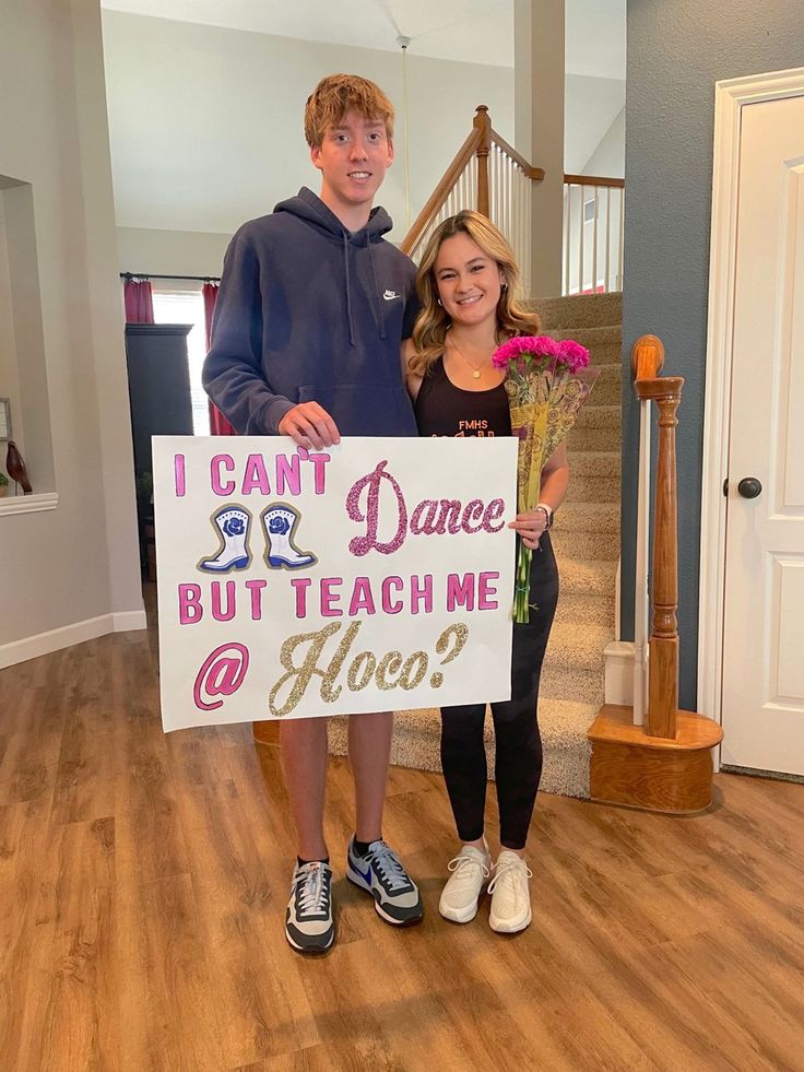 two people holding a sign that says i can't dance but teach me hoo