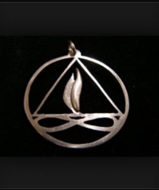 a silver pendant with an image of a candle in the center