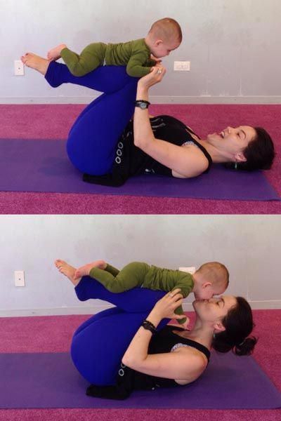 a woman holding a baby on her back while doing yoga exercises for the child's stomach