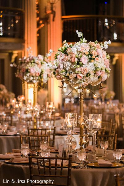 the centerpieces are filled with pink and white flowers in tall vases on top of round tables