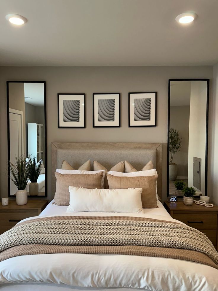 a large bed sitting under three mirrors in a bedroom