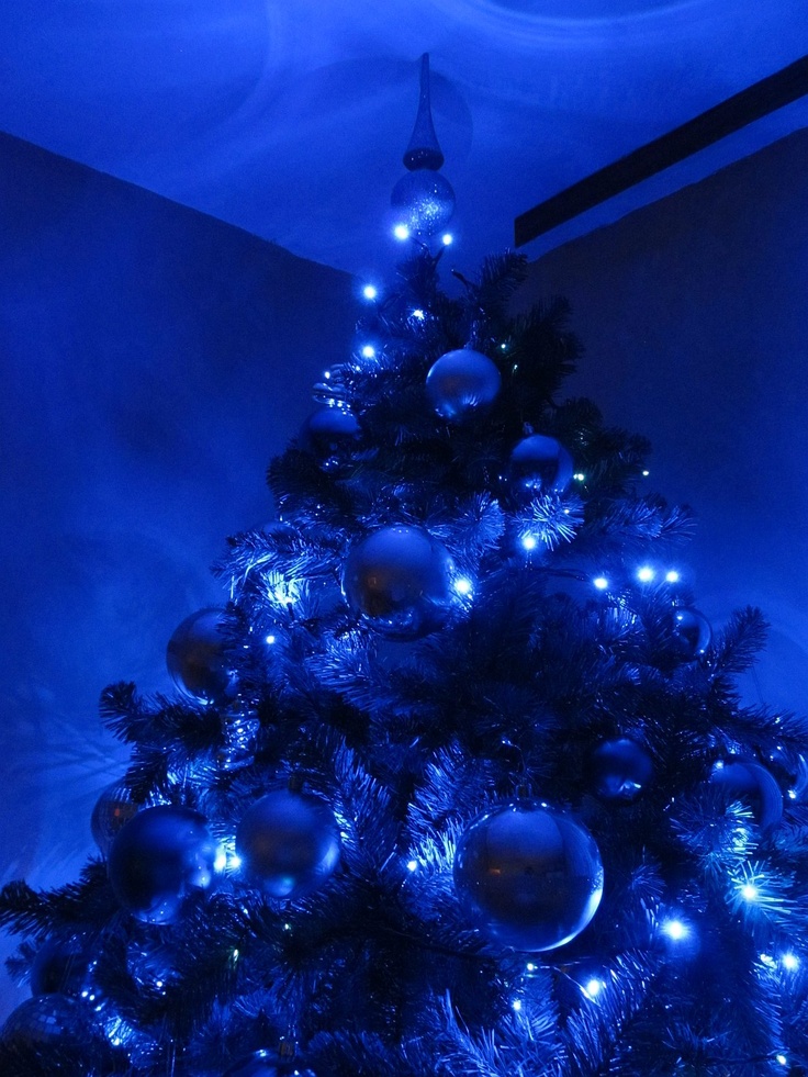 a blue christmas tree with ornaments and lights