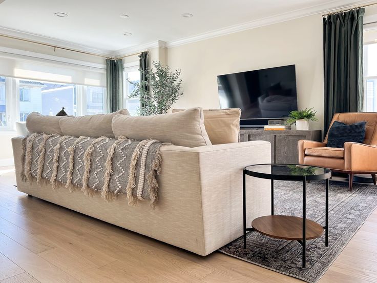 a living room filled with furniture and a flat screen tv mounted on the wall above it