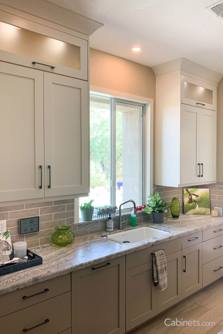 a kitchen with white cabinets and granite counter tops, along with an open window to the outside