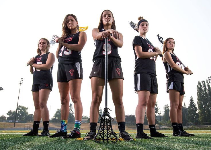 a group of young women standing next to each other on top of a field