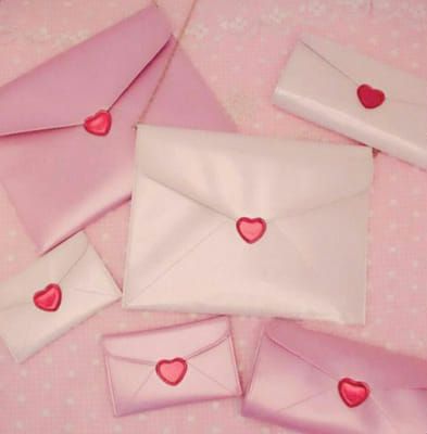 four envelopes with hearts on them sitting on a table