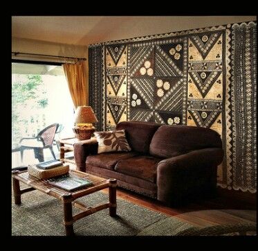 a living room filled with furniture and a large tapestry on the wall above it's windows