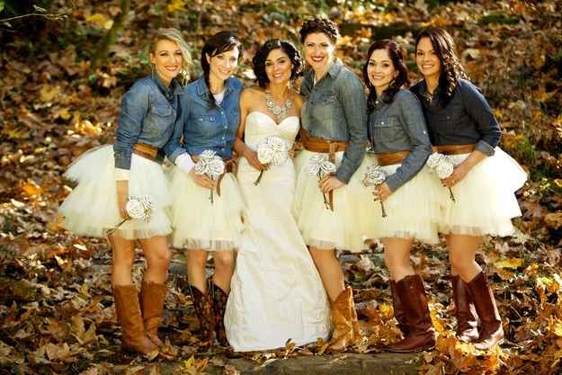 a group of women standing next to each other in front of trees and leaves on the ground