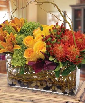 a vase filled with lots of different colored flowers