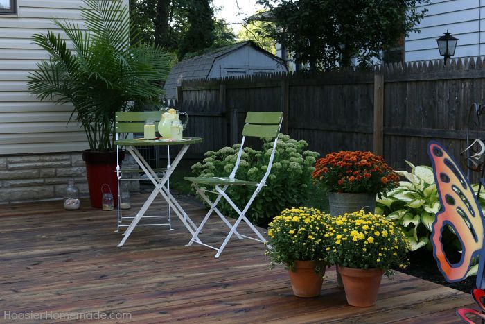 a deck with chairs and potted plants on it