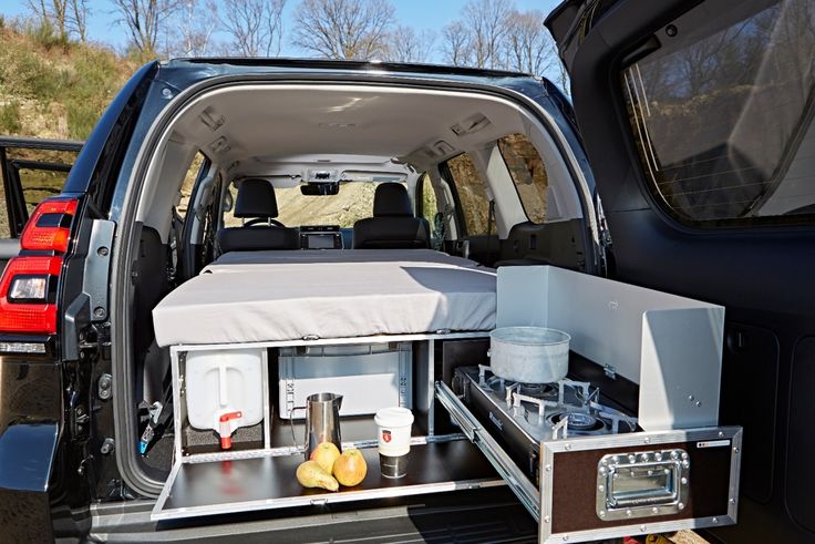 the back end of a van with an open trunk and food trays in it