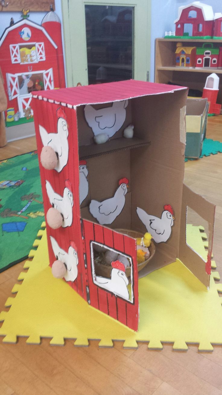 an open cardboard box sitting on top of a wooden floor in a room filled with toys