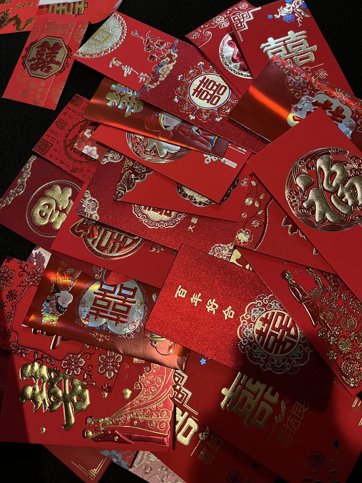 a pile of red envelopes with chinese writing on them, all covered in gold foil