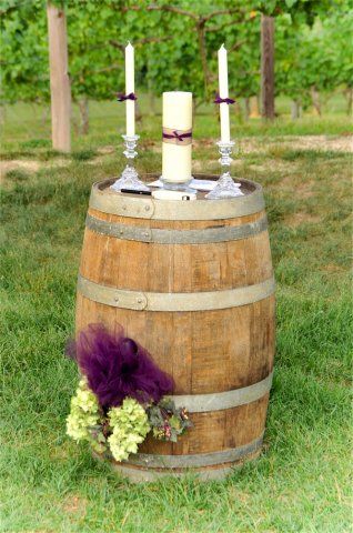 two candles are placed on top of a barrel