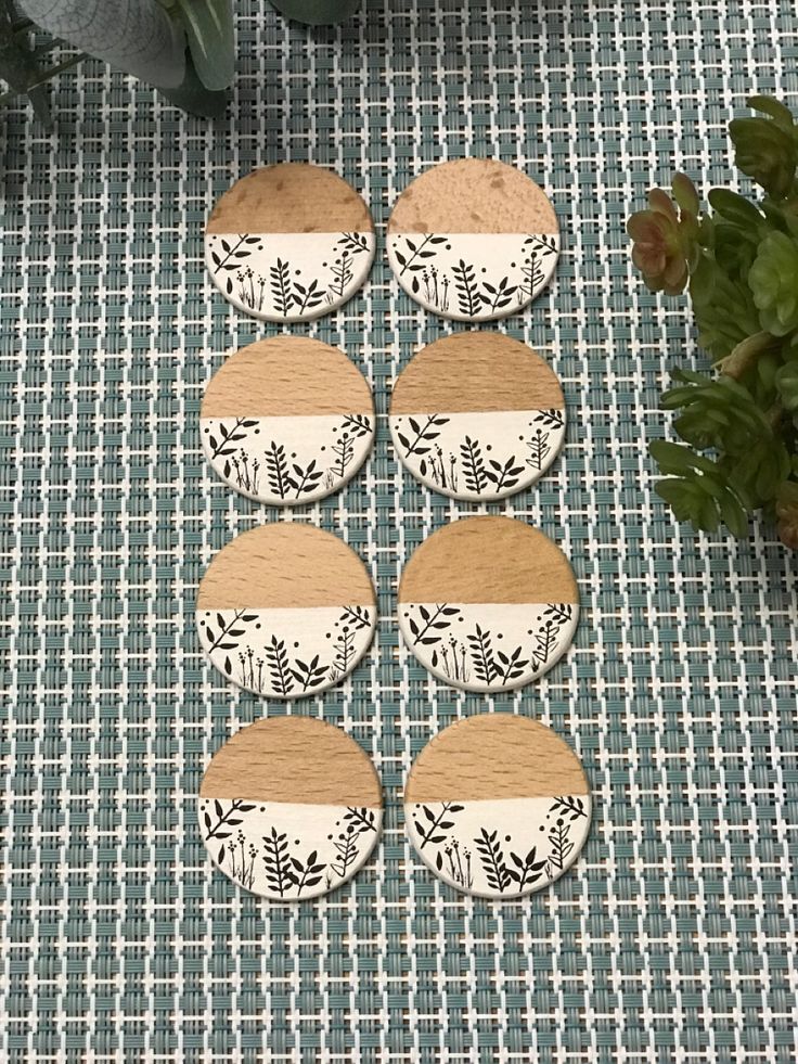 six cupcakes sitting on top of a table next to a potted plant