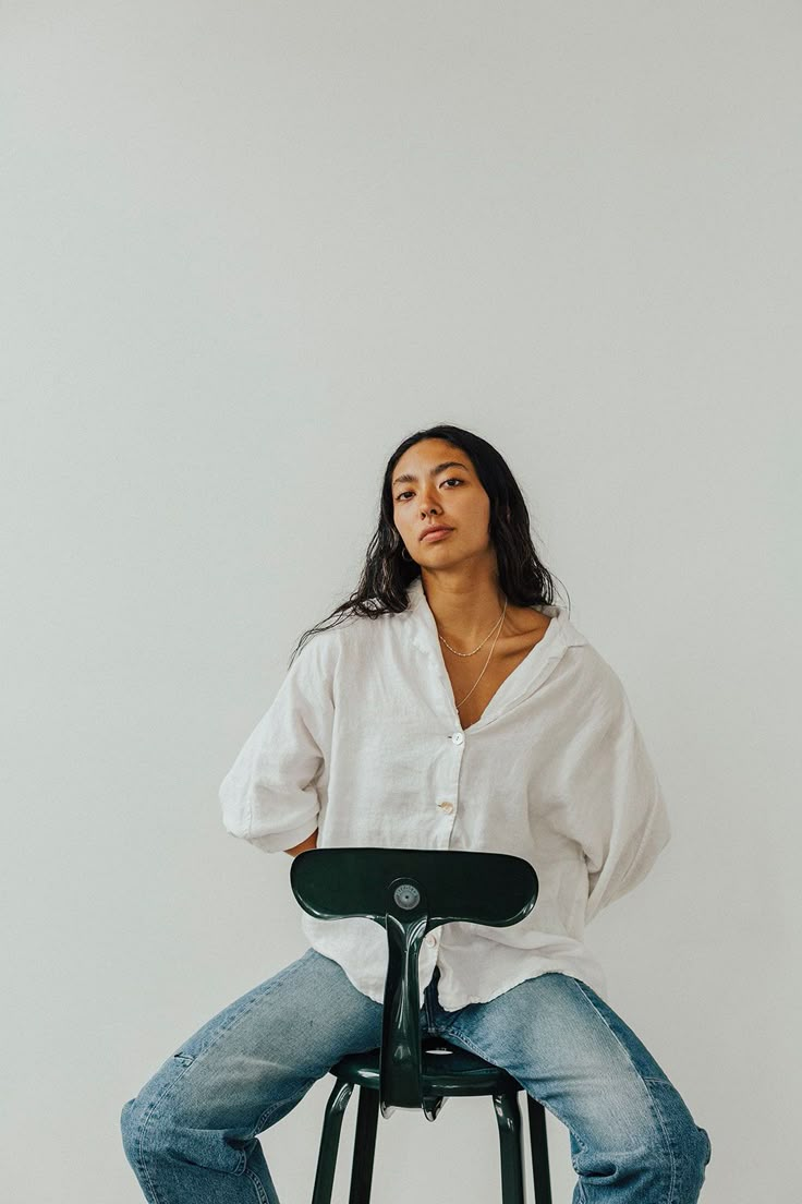 a woman sitting on top of a black stool