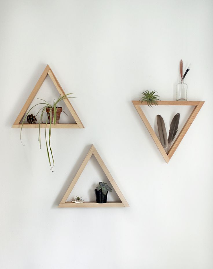 three wooden shelves with plants and vases on them, one is shaped like triangles