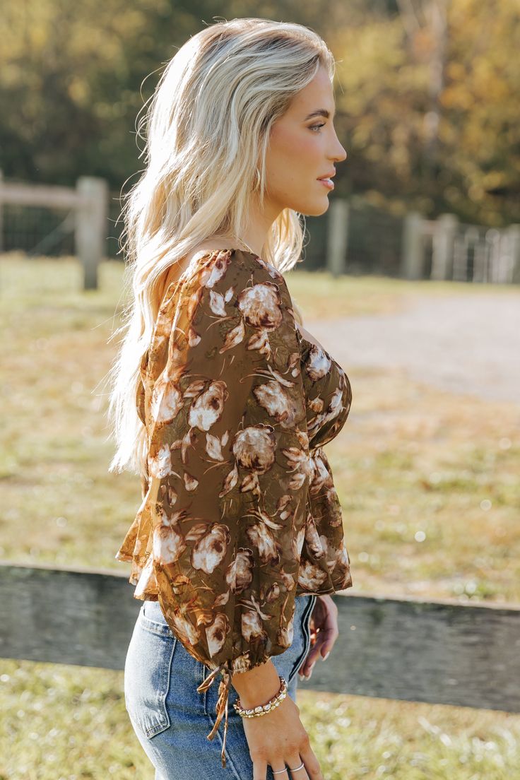 Embrace boho-chic vibes with the Olive Multi Floral Print Blouse, perfect for adding a touch of romance to any outfit! Features 3/4 sleeve length with delicate tie cuffs for a feminine flair. Designed with a square neckline and an elastic waistband for a flattering silhouette. The flowy hem creates a graceful movement, making it a versatile piece for day or night. Pair it with your favorite jeans or a skirt for an effortlessly stylish look. Chic Blouse With Floral Print And 3/4 Sleeves, Brown Square Neck Top For Spring, Spring Bell Sleeve Blouse With Tie Sleeves, Spring Blouse With Tie Sleeves And Bell Sleeves, Chic 3/4 Sleeve Spring Blouse, Spring Blouse With Tie And Bell Sleeves, Flowy Fall Blouse With 3/4 Sleeves, Chic Square Neck Blouse For Fall, Trendy 3/4 Sleeve Blouse For Fall