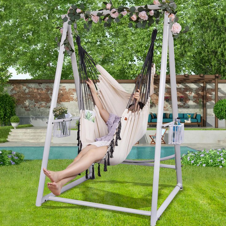 a woman laying in a hammock chair on the grass