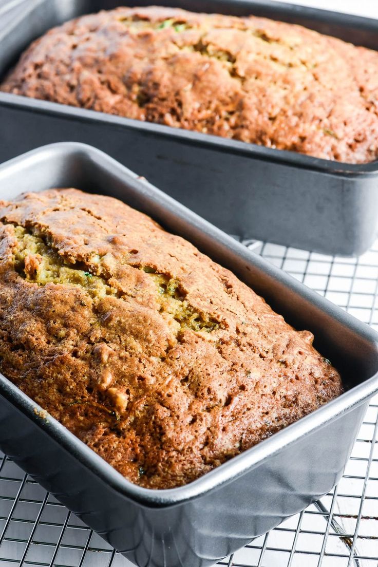 two loafs of banana bread sitting on top of a cooling rack next to each other