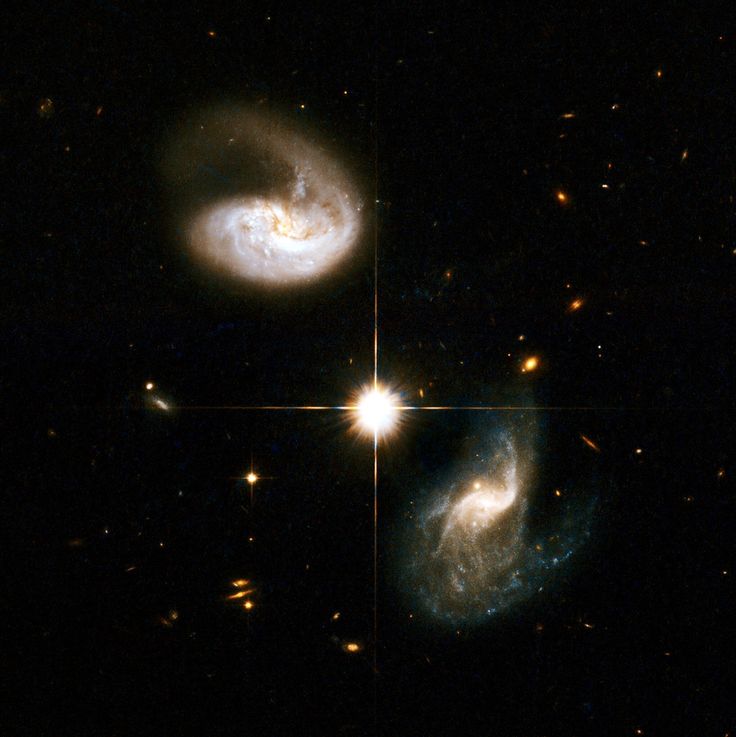 two spiral shaped objects in the dark sky