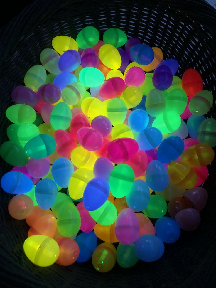 a basket filled with lots of bright colored plastic eggs