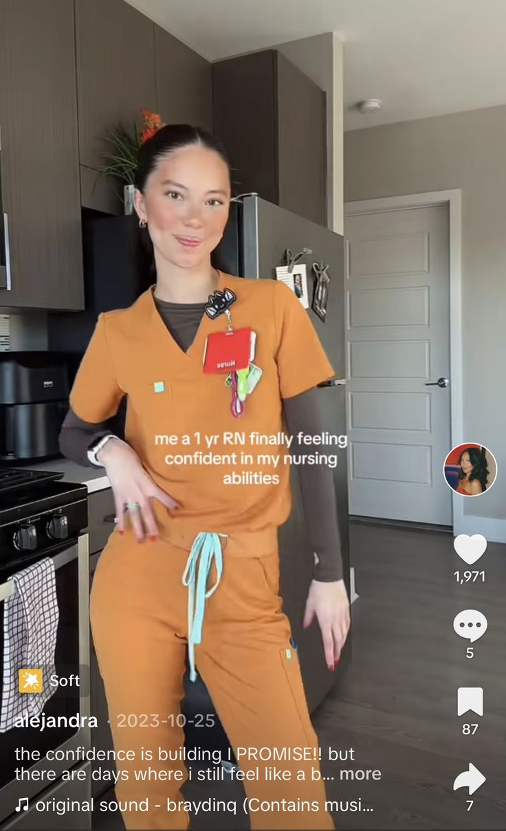 a woman in an orange scrub suit is smiling