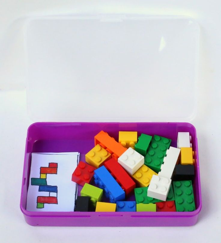 a purple container filled with legos on top of a white table