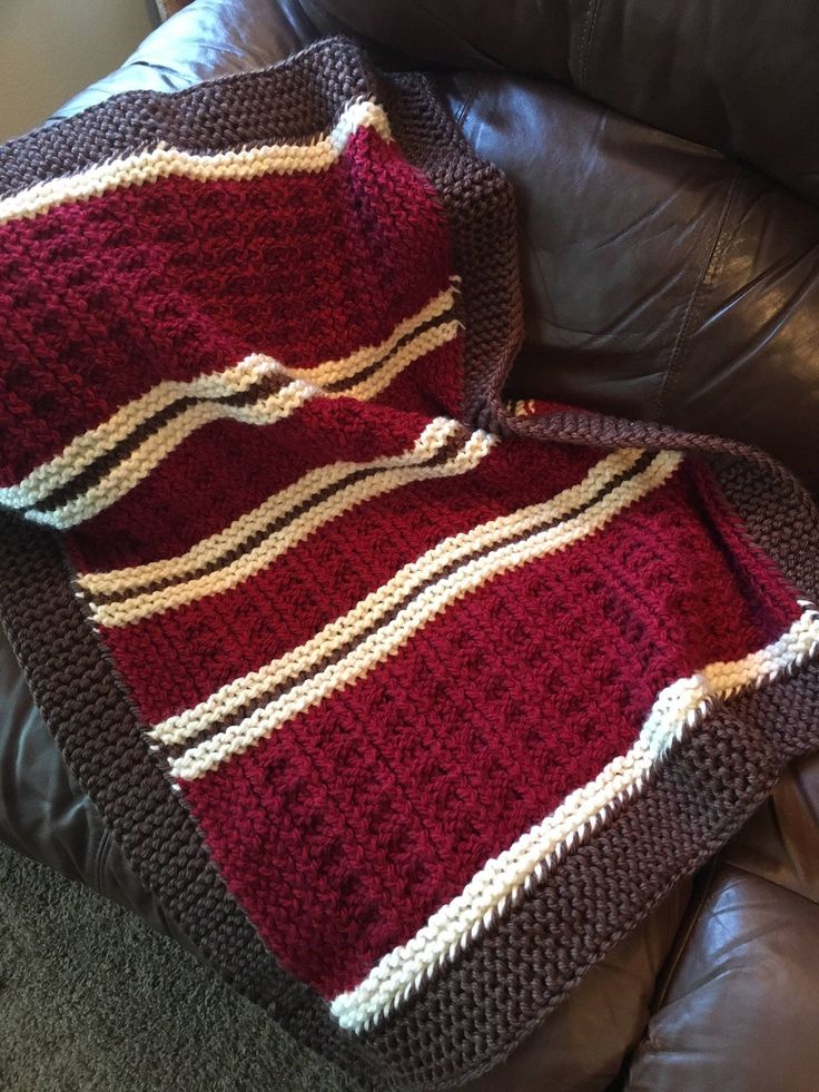 a crocheted blanket sitting on top of a leather couch