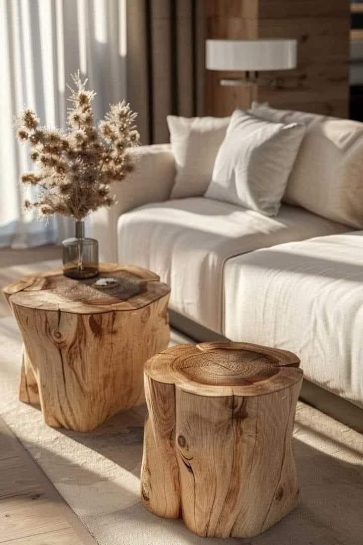 two wooden tables sitting next to each other in front of a couch with pillows on it