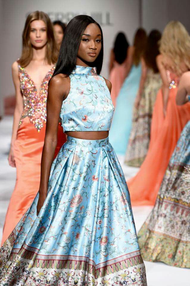 models walk down the runway in colorful dresses