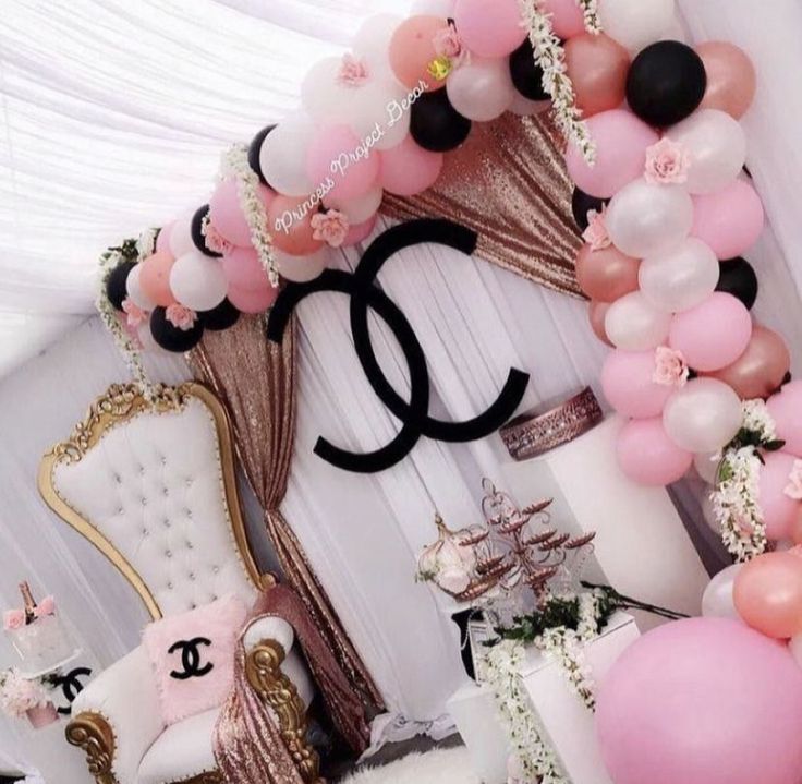 the balloon arch is decorated with pink, white and black balloons for a chanel themed birthday party