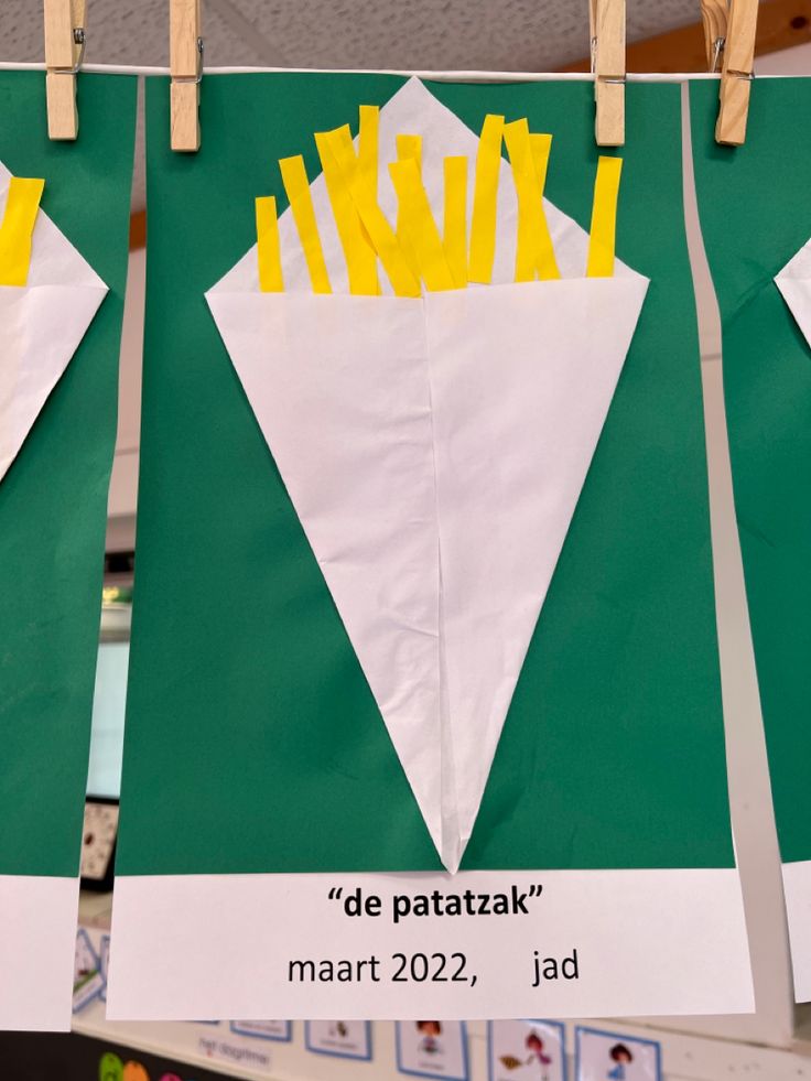 three pieces of paper with french fries on them hanging from clothes pegs in the classroom