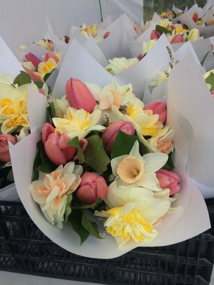 a bunch of flowers that are sitting in some paper wrappers on a table together