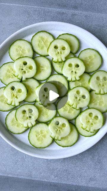 a white plate topped with sliced cucumbers on top of a gray countertop