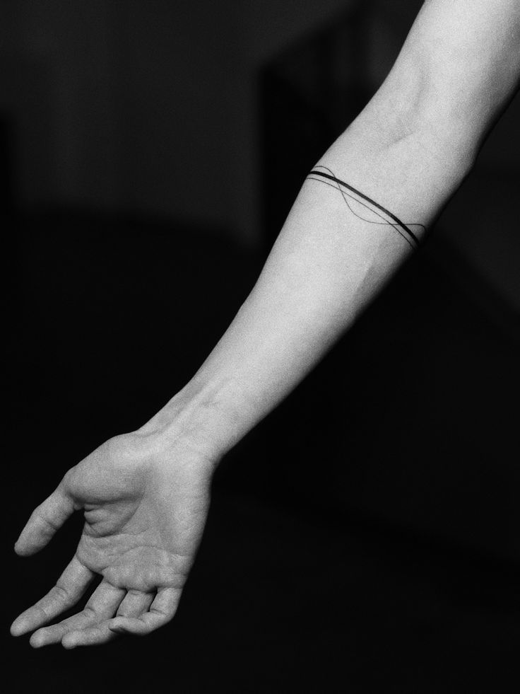 a black and white photo of a person's arm with a tattoo on it