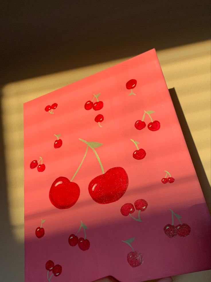 a piece of paper that has cherries on it and is cut out to look like a cherry