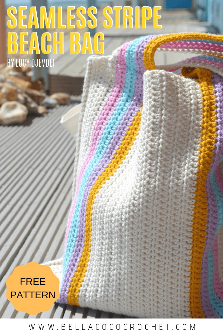 a crocheted beach bag sitting on top of a wooden bench next to the ocean