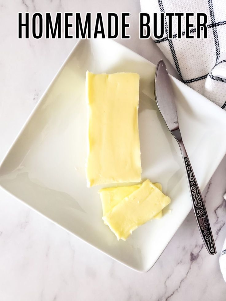 a white plate topped with butter next to a knife and fork on top of a marble counter