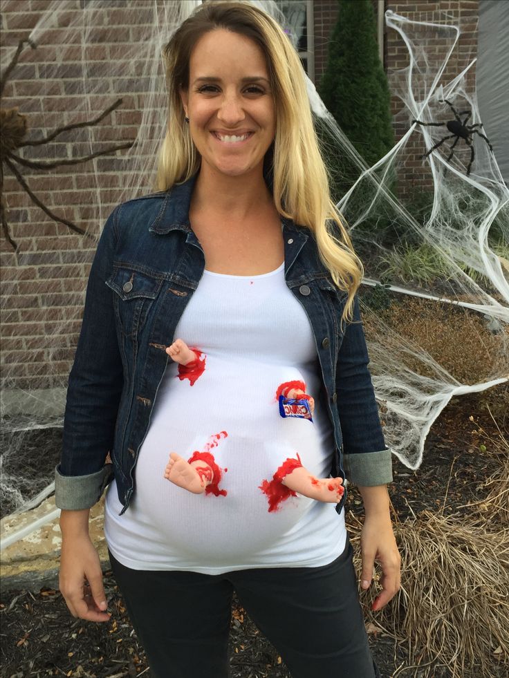 a pregnant woman with her handprints on her belly, smiling at the camera