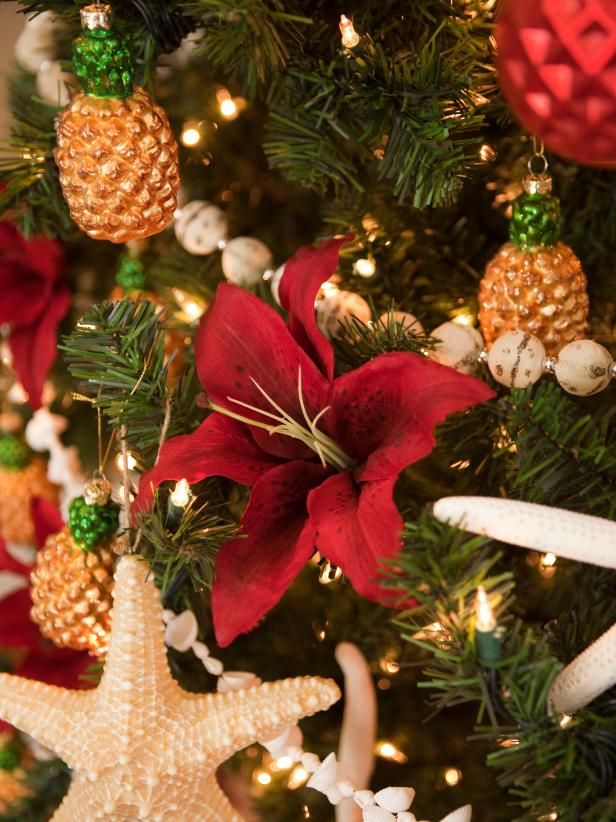 the christmas tree is decorated with poinsettis and starfish ornaments, which are red and gold